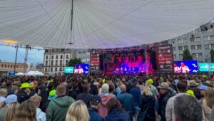 Eine große Menge an Zusehern steht vor der Bühne und lauscht der Musik