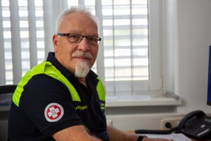 Walter Barth in blauer Uniform am Schreibtisch sitzend