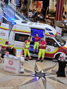Sanitäter stehen auf einem Stand der Krone Gesund Tage vor einem Rettungsfahrzeug