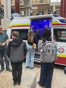 Besucher:innen vor einem Rettungsfahrzeug