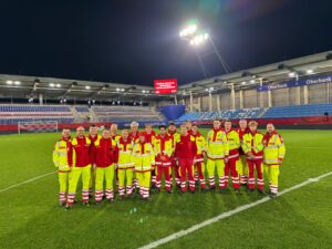 Gruppenfoto von Sanitäter:innen auf dem Rasen im Linzer Hofmann Stadion