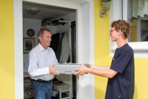 Ein Samariter übergibt eine Essen auf Rädern Box