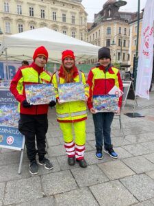Samariter bei Verkaufsstand am Taubenmarkt Linz mit Kalender in der Hand